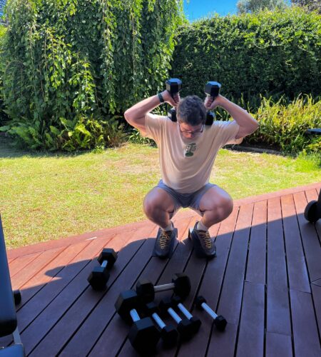 Personal trainer performing a dumbbell front squat